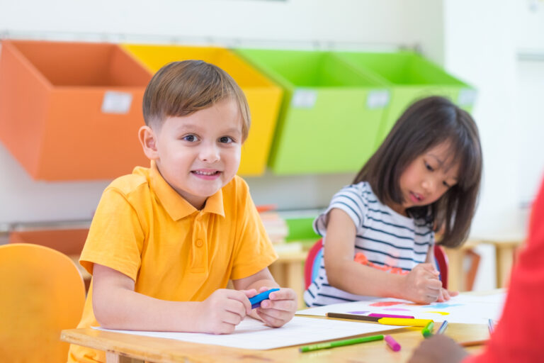 Caucasian boy ethnicity kid smiling white learning in classroom with friends and teacher  in kindergarten school, education concept