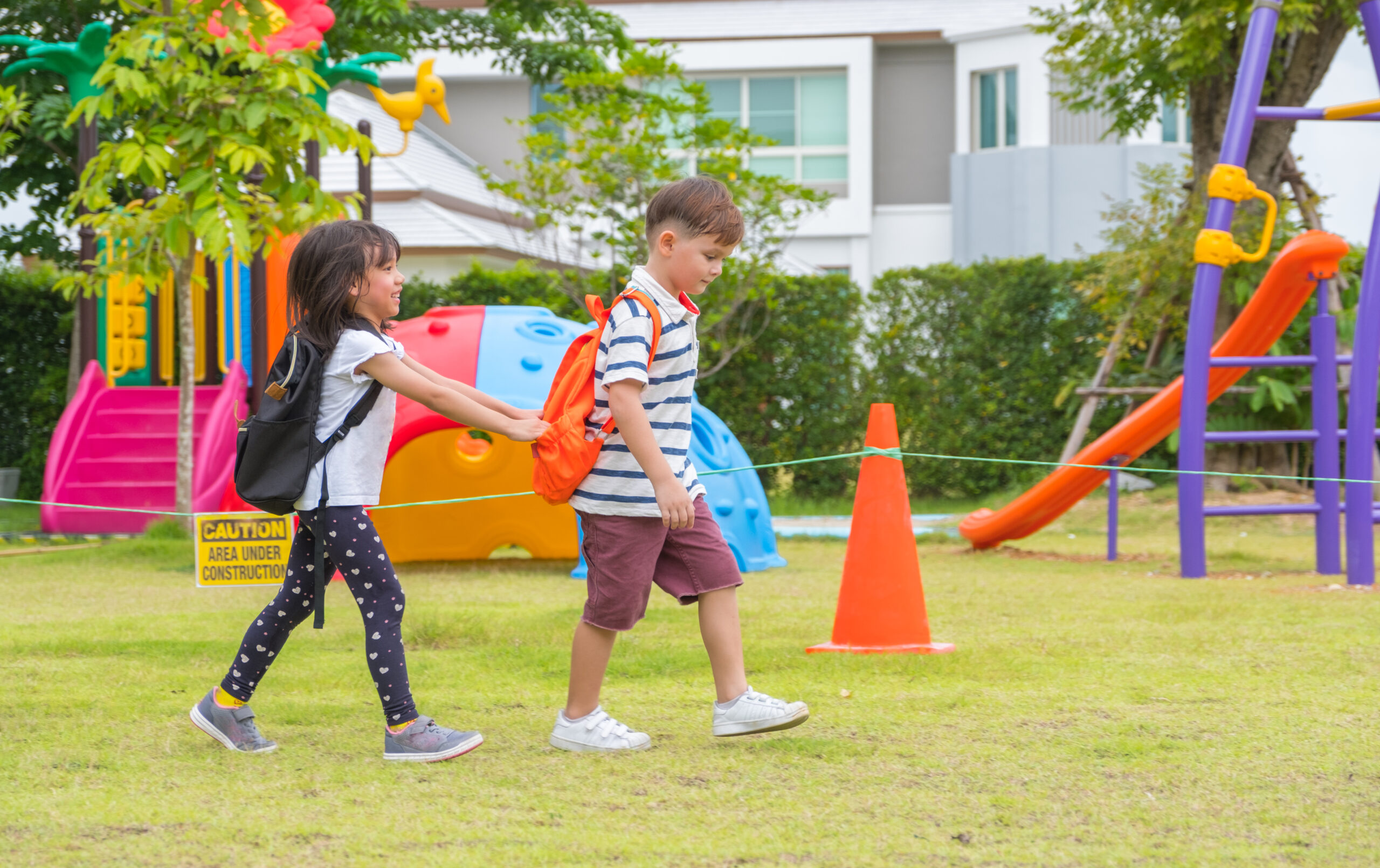 Two kid school children walking at playground in kindergarten preschool.back to school